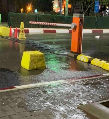 a wet street with a yellow block on the road at F5 -5 bedrooms Apt- Residence Hasnaoui avec parking Oran Algeria in Oran