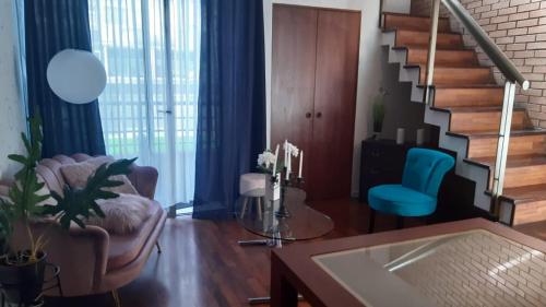 a living room with a staircase and a blue chair at loft barrio lastarria in Santiago