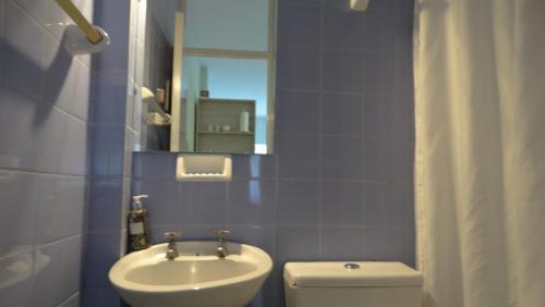 a bathroom with a sink and a toilet and a mirror at Monoambiente en pleno centro de Adrogué in Adrogué