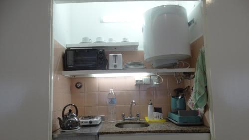 a small kitchen with a sink and a microwave at Monoambiente en pleno centro de Adrogué in Adrogué
