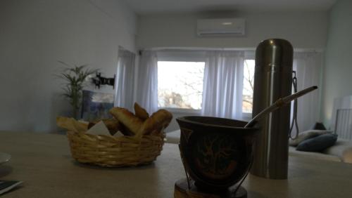 a basket of bread and a cup on a table at Monoambiente en pleno centro de Adrogué in Adrogué