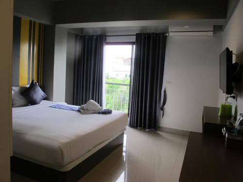 sypialnia z dużym łóżkiem i oknem w obiekcie Suvarnabhumi Oriental Resort w Lat Krabang