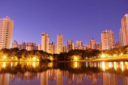 eine Skyline der Stadt in der Nacht mit einem See und Gebäuden in der Unterkunft Hostel Bimba Goiânia - Unidade 02 in Goiânia