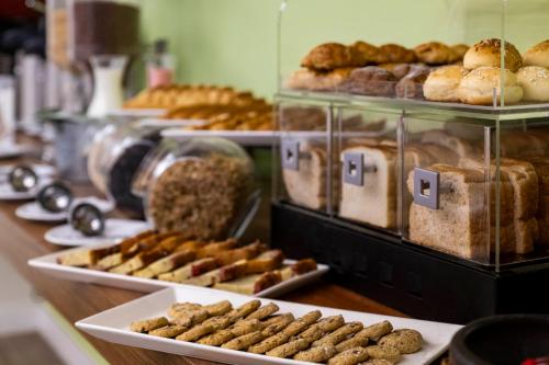 a display case with various types of donuts and pastries at Hotel Vilar América in Bogotá