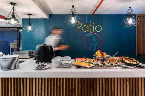 a buffet line with food and a man in the background at Hotel Vilar América in Bogotá