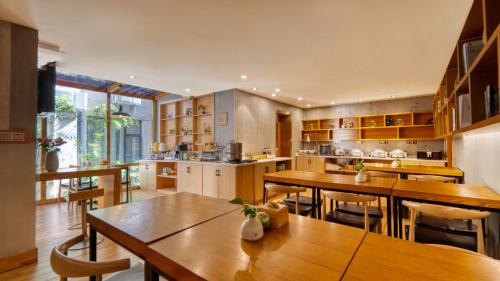 a large kitchen with wooden tables and chairs at Gongxili - Chujian Hotel in Kunming