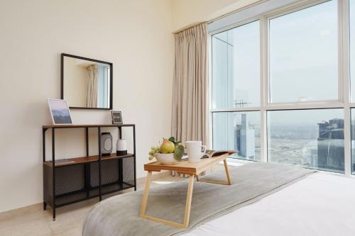 a living room with a table and a large window at Maison Privee - Lovely Apt with Lake Walkways Close to JBR Beach in Dubai