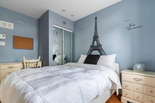 a bedroom with a white bed with the eiffel tower at Live like a Montrealer in this 3-bedroom home! in Montréal