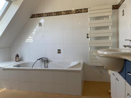 uma casa de banho com uma banheira e um lavatório em Maison Locoal-Mendon, 4 pièces, 6 personnes - FR-1-397-74 em Locoal-Mendon