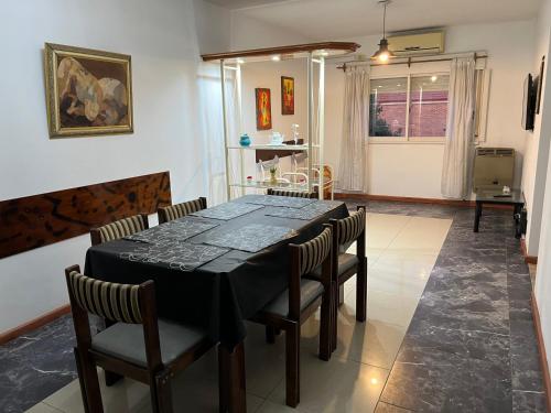 a dining room with a black table and chairs at DEPARTAMENTO AHNEN CORDOBA - Cerca Instituto Cardiologico, Ferial Cordoba, Hospital Privado Cerro y Sanatorio Allende in Córdoba