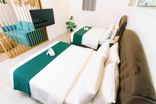 two beds in a room with a tv at 3 Peaks Resort & Boutique Hotel in Lipa