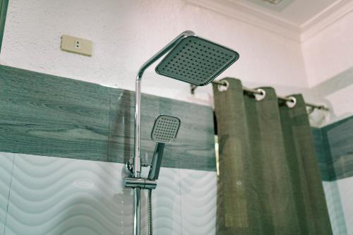 a shower in a bathroom with a shower curtain at 3 Peaks Resort & Boutique Hotel in Lipa