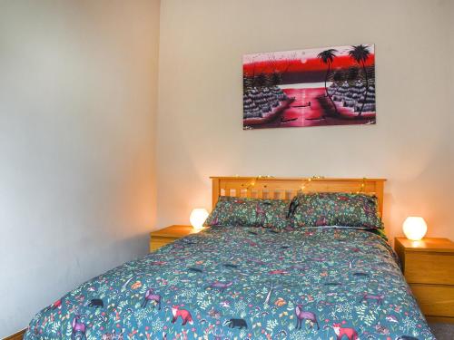 1 dormitorio con 1 cama con colcha colorida en The Old Boot Room en Llanfynydd