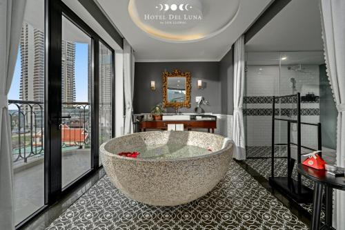a bathroom with a large tub on a balcony at Hotel Del Luna Boutique in Da Nang