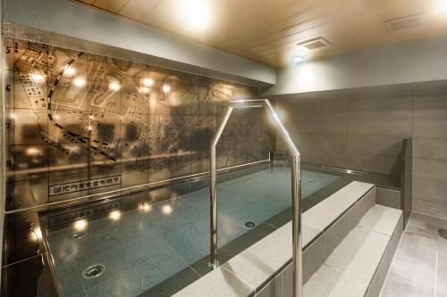 a swimming pool in a building with a wall at Via Inn Shimonoseki in Shimonoseki
