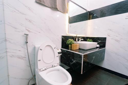 a bathroom with a white toilet and a sink at 3 Peaks Resort & Boutique Hotel in Lipa