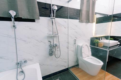 a bathroom with a shower and a toilet and a sink at 3 Peaks Resort & Boutique Hotel in Lipa
