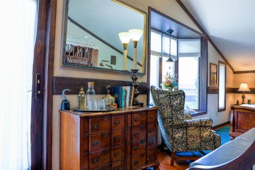 a room with a dresser and a chair and a mirror at Stone Chalet Bed & Breakfast Inn in Ann Arbor