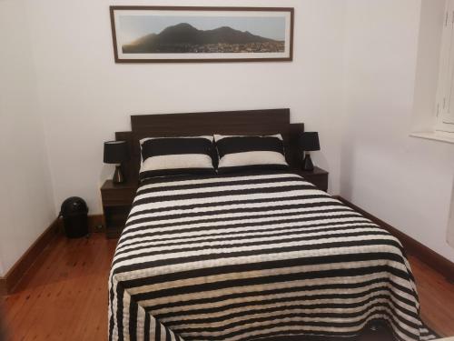 a bedroom with a bed with a black and white striped blanket at La Casona Hospedaje in Lima