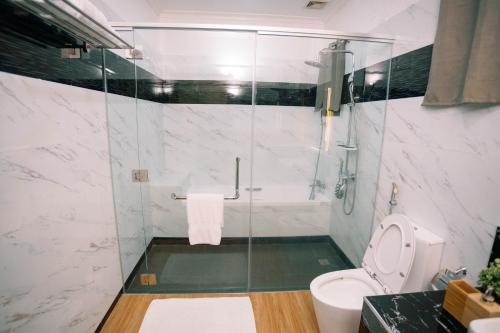a bathroom with a toilet and a glass shower at 3 Peaks Resort & Boutique Hotel in Lipa