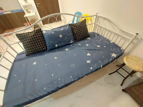 een bed met een blauw laken met sterren erop bij Twin Eleven in Kota Bharu