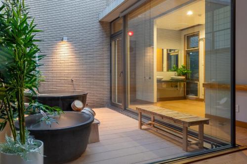 a bath tub and a bench on a patio at AOI Sauna SPA & Dog Villa HAKODATE in Hakodate
