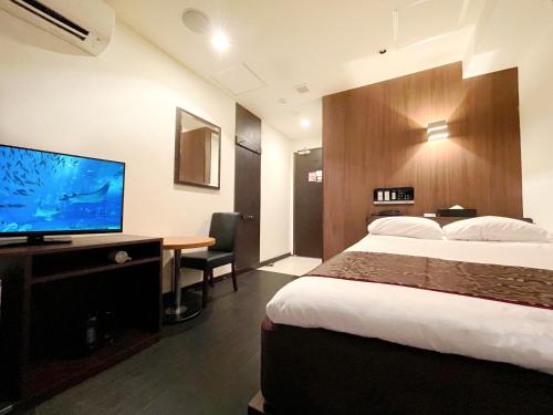 a hotel room with a bed and a flat screen tv at Ikebukuro Grand Hotel in Tokyo