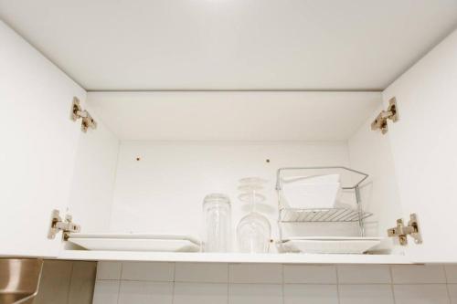 a white kitchen with two sinks and bottles on a shelf at Feeling Home, while away in Kitchener