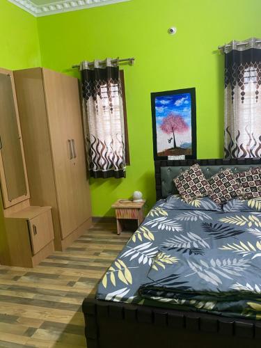 a bedroom with a bed and a green wall at Ghar-fully furnished house with 2 Bedroom hall and kitchen in Bangalore