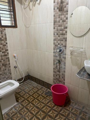 a bathroom with a toilet and a sink and a bucket at Ghar-fully furnished house with 2 Bedroom hall and kitchen in Bangalore