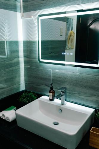 a white sink in a bathroom with a mirror at 3 Peaks Resort & Boutique Hotel in Lipa