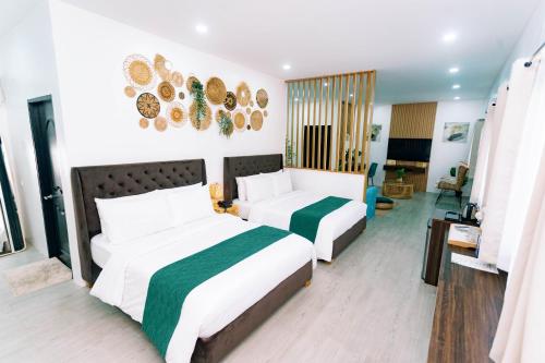 a bedroom with two beds and a living room at 3 Peaks Resort & Boutique Hotel in Lipa