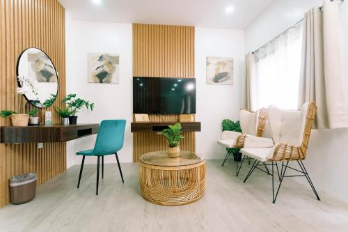 a living room with a tv and a table and chairs at 3 Peaks Resort & Boutique Hotel in Lipa