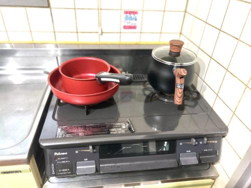a red pot sitting on top of a stove at Hotel KinRin in Tokyo