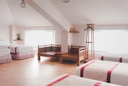 太平村的住宿－幸福旅行舍，一间设有四张床和一张书桌的房间
