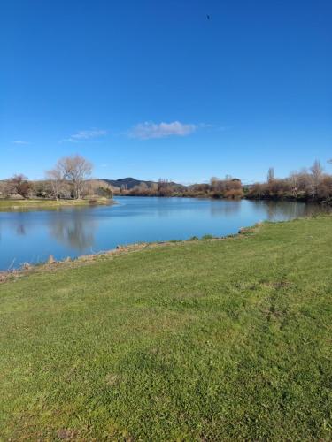 uma vista para um lago com um campo de relva em The Ferry Hotel em Wairoa