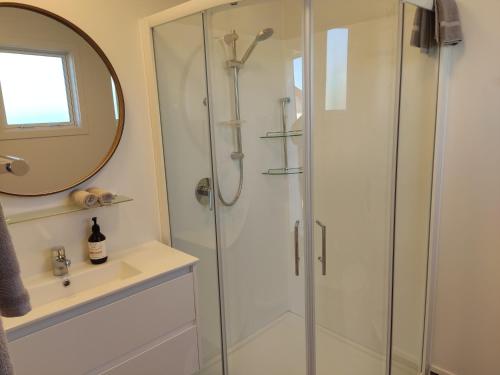 uma casa de banho com um chuveiro e um espelho. em The Ferry Hotel em Wairoa