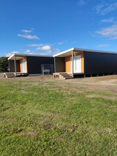 un edificio con un campo de césped delante de él en The Ferry Hotel, en Wairoa