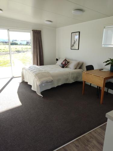 ein Schlafzimmer mit einem großen Bett und einem Schreibtisch in der Unterkunft Studios On Carroll - ex Ferry Hotel in Wairoa
