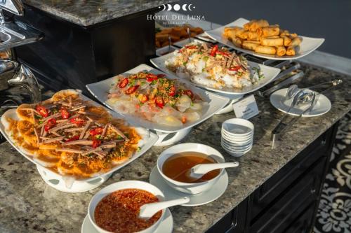 a buffet with many different dishes of food on a counter at Hotel Del Luna Boutique in Da Nang