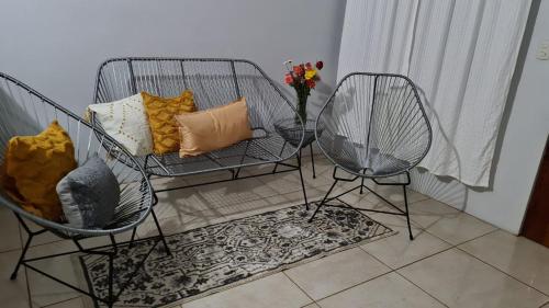 dos sillas y un sofá con un jarrón de flores en Casa Apreta2, en San Isidro