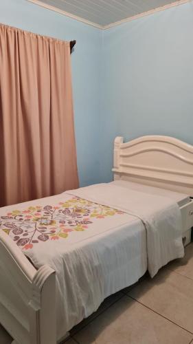 1 dormitorio con 1 cama con edredón blanco en Casa Apreta2, en San Isidro
