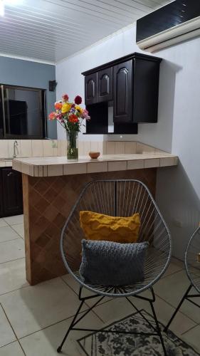 una cocina con una barra con un jarrón de flores en Casa Apreta2, en San Isidro