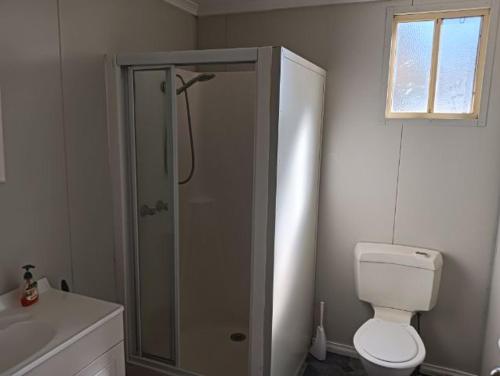 a bathroom with a shower and a toilet and a sink at Sunraysia Holiday Park in Mildura