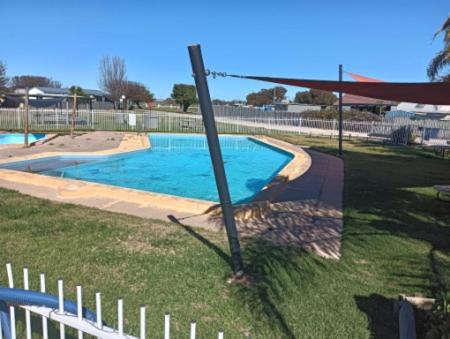 un palo nell'erba accanto a una piscina di Sunraysia Holiday Park a Mildura