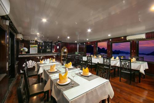 a restaurant with tables and chairs in a room at Fantasea Imperial Cruise in Ha Long