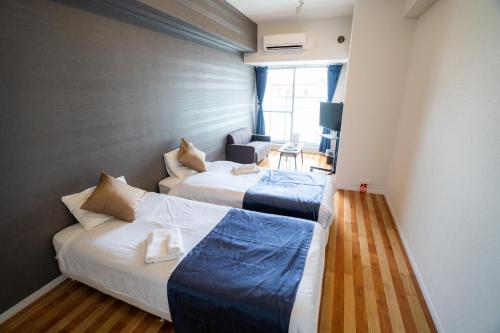 Habitación de hotel con 2 camas y TV en S-Presso Namba Parks Street, en Osaka