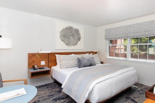 a bedroom with a bed and a table and a window at Carmel Beach Hotel in Carmel