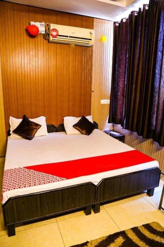 um quarto com uma cama grande e um cobertor vermelho em Hotel royal orbit em Zirakpur
