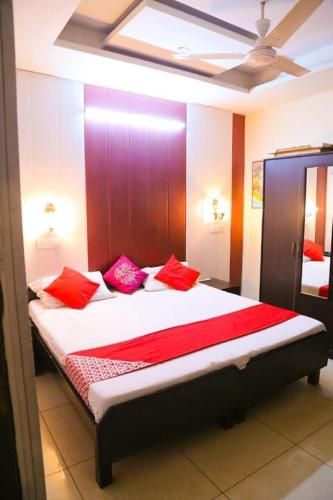 um quarto com uma cama grande e almofadas vermelhas em Hotel royal orbit em Zirakpur